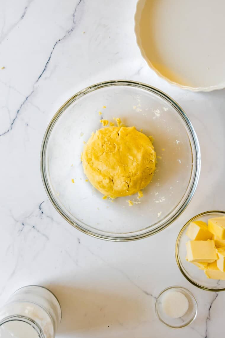 A ball of pie dough in a glass bowl.