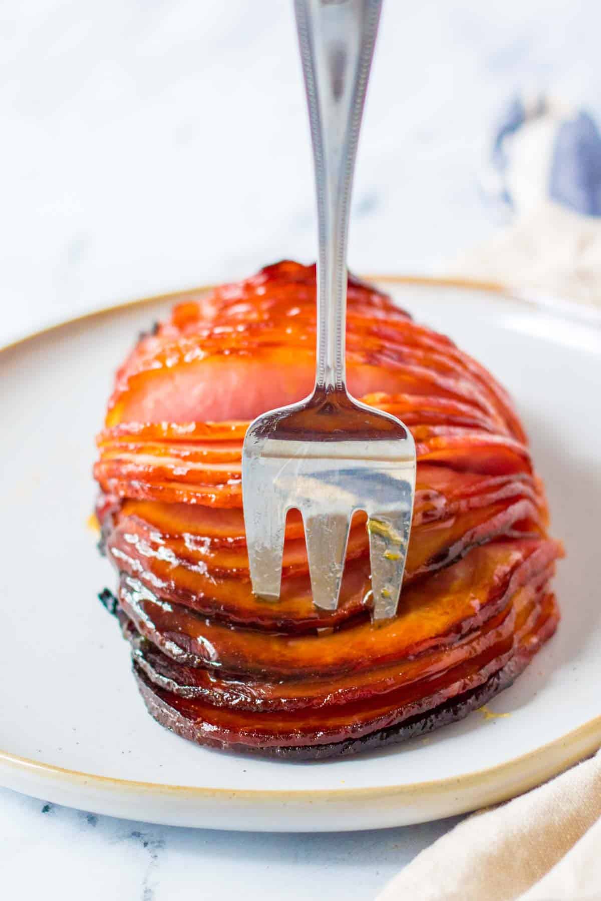 meat fork in a sliced boneless ham