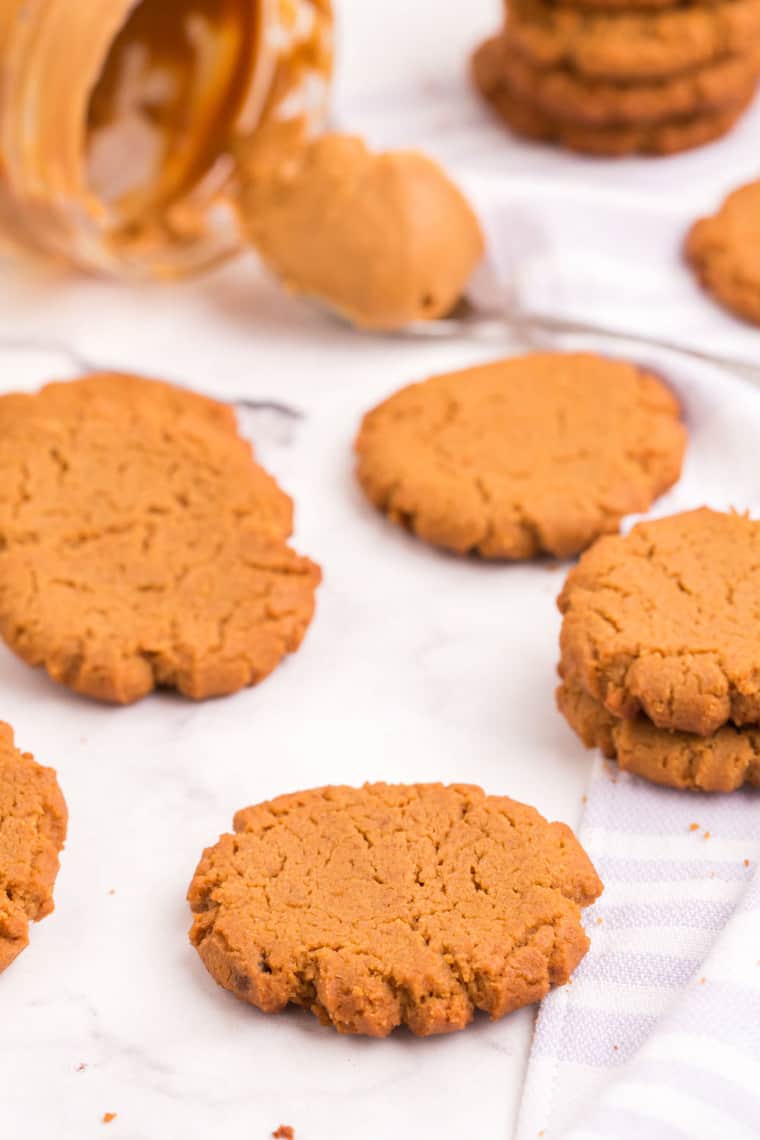 cookies scattered around a jar of peanut butter