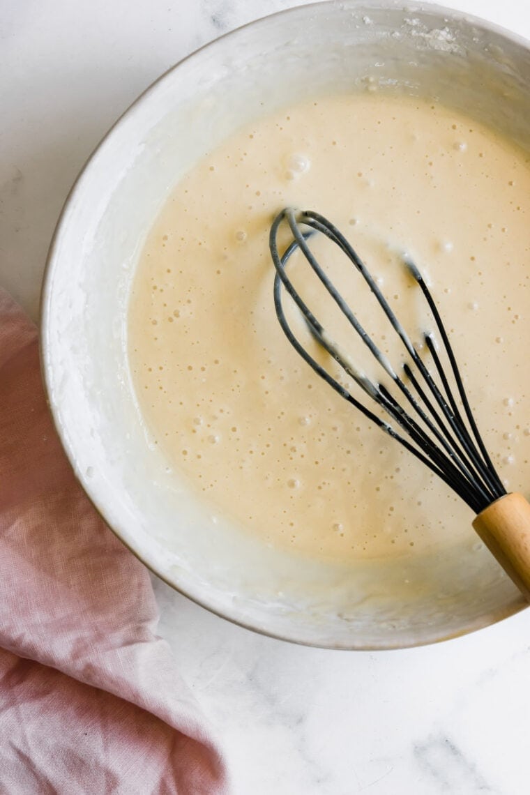 A Bowl of Vanilla Cupcake Batter with a Whisk Inside