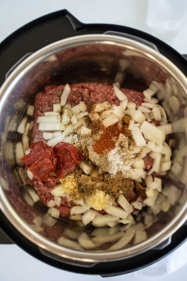 Ground Beef, Cheese, Spices and Tomato Paste in the Bowl of an Instant Pot