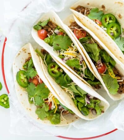 A Plate of Instant Pot Tacos Filled with Veggies and Cheese