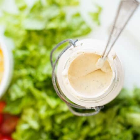 top of a bottle of creamy southwestern dressing surrounded by salad veggies