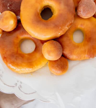 Five Donuts and Six Munchkin Donuts on a Cake Stand Draped with Parchment Paper