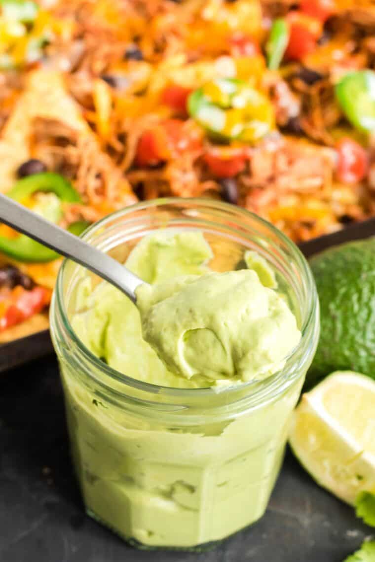 spooning avocado cream out of a jar