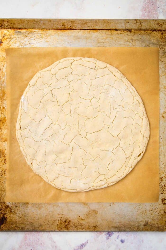 par-baked gluten free pizza crust on a baking sheet