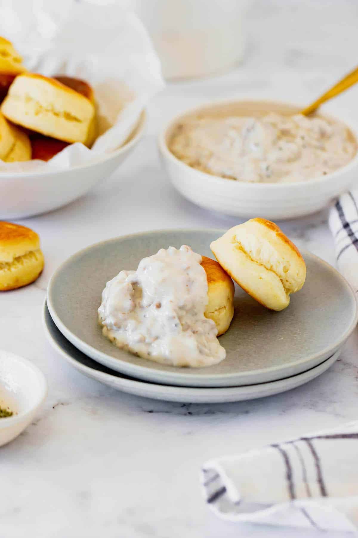 Two Buttermilk Biscuits on a Plate with a Heaping Scoop of Sausage Gravy