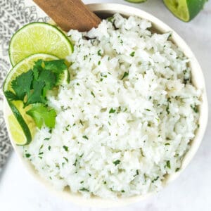 white bowl of cilantro lime riche with a wooden serving spoon