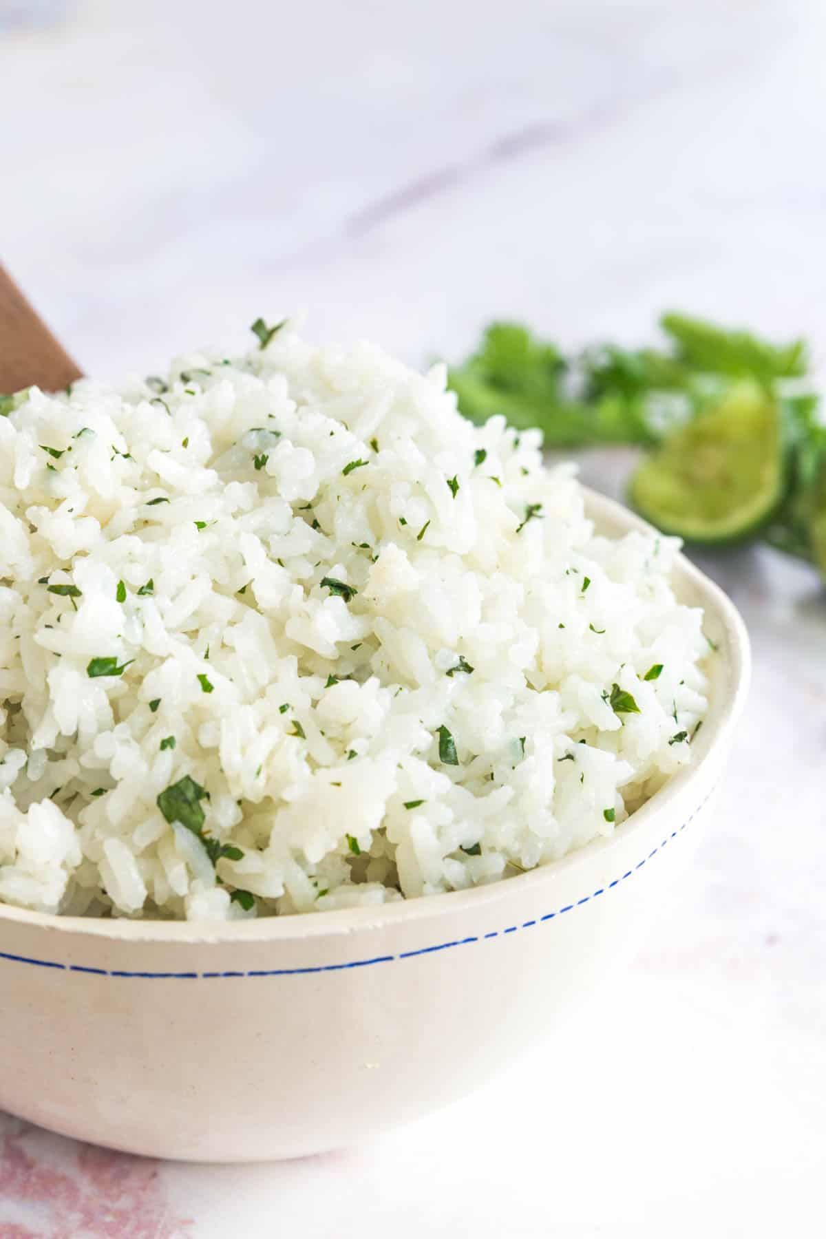 a serving bowl of white rice with minced cilantro leaves mixed in