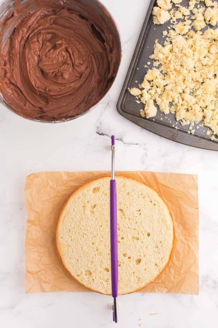 using a cake leveler to cut the rounded top off of the cake