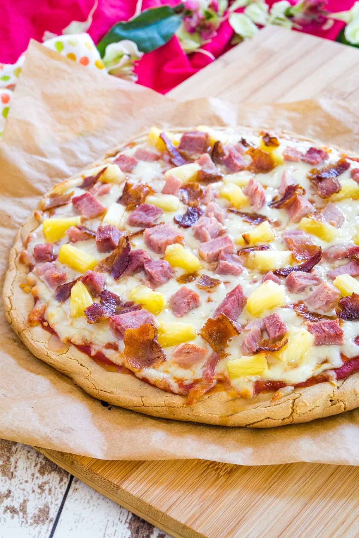 freshly baked hawaiian pizza on a cutting board