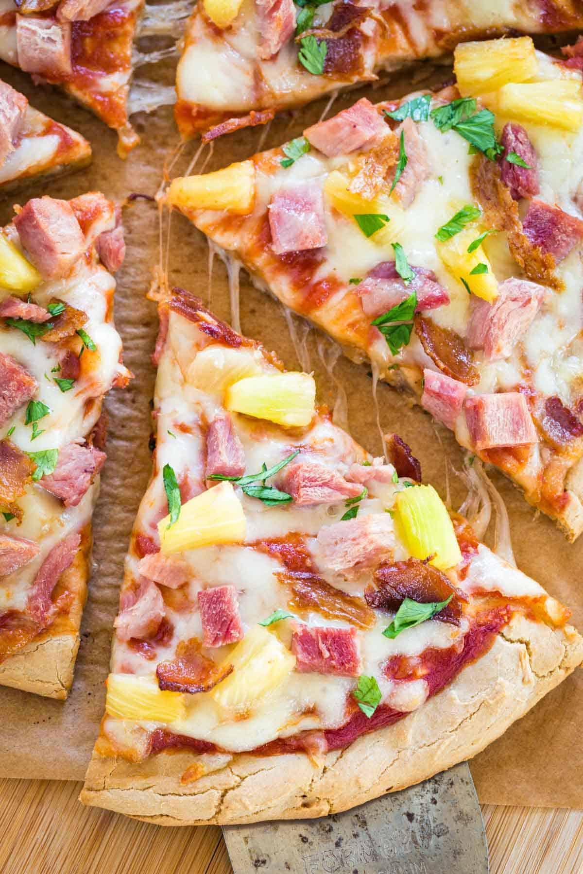 Slice of Hawaiian Pizza being pulled away from the rest