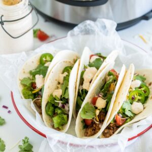 ground beef tacos on a plate in front of an Instant pot
