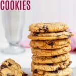 a stack of eight chocolate chip cookie on a rack with one next to it broken in half and a glass of milk behind them