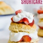 one strawberry shortcake with strawberries and whipped cream between the two biscuit layers and on top