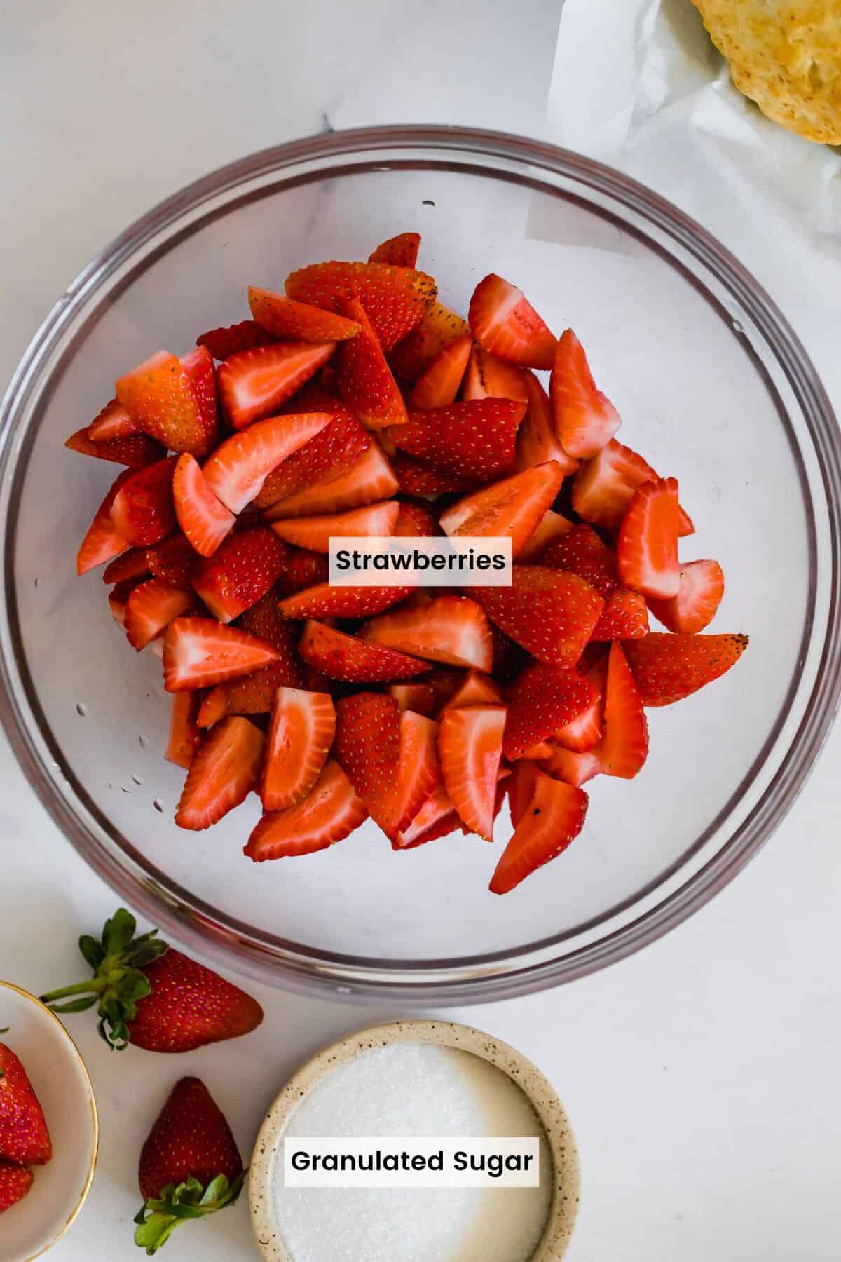 Quartered strawberries and sugar in a bowl