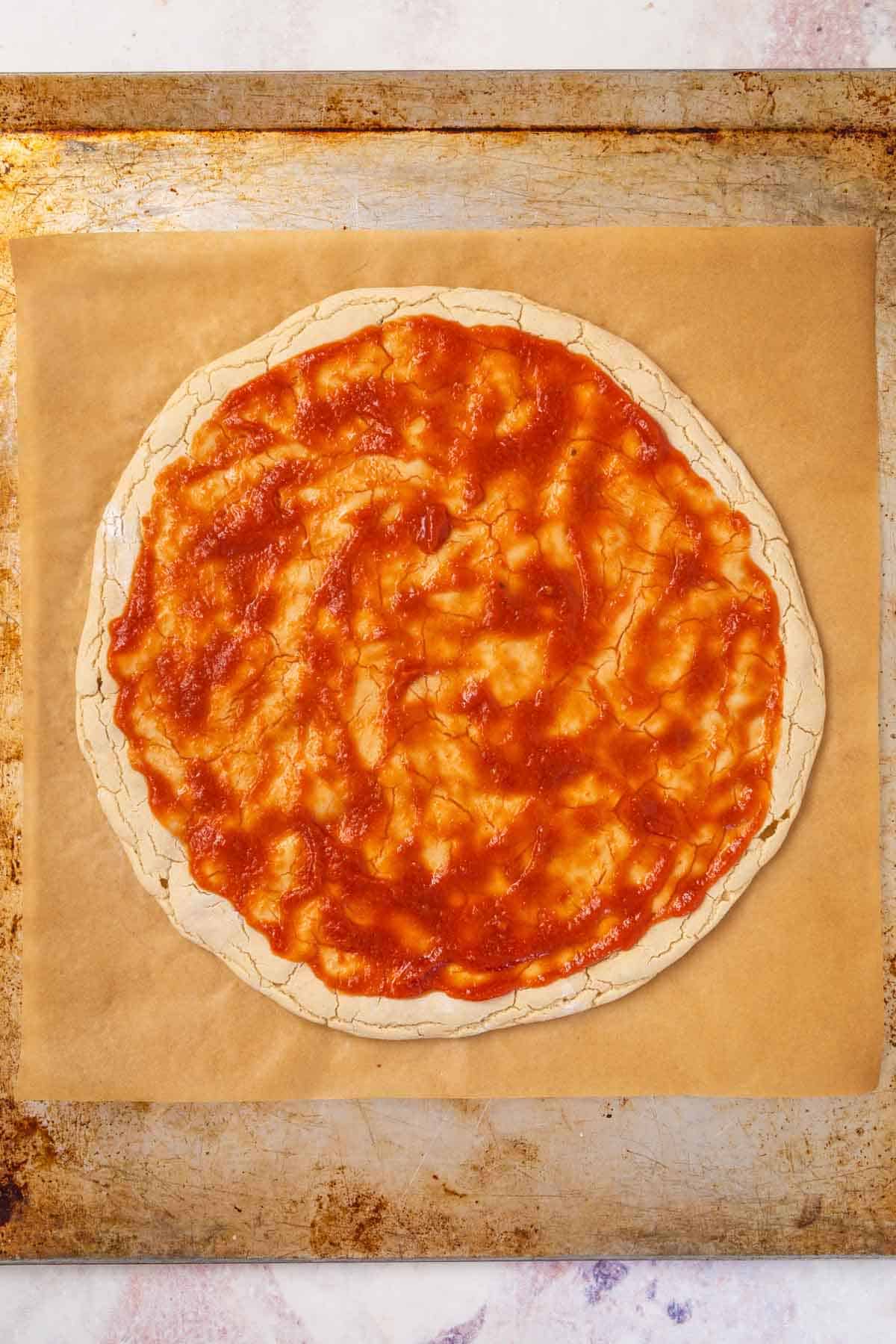 A Layer of Pizza Sauce Spread on Top of a Gluten-Free Pizza Crust