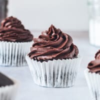 A Gluten Free Chocolate Cupcake with Chocolate Frosting and a White Cupcake Liner