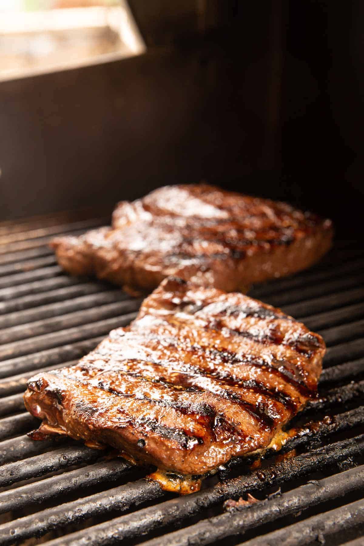 steaks cooking on the grill