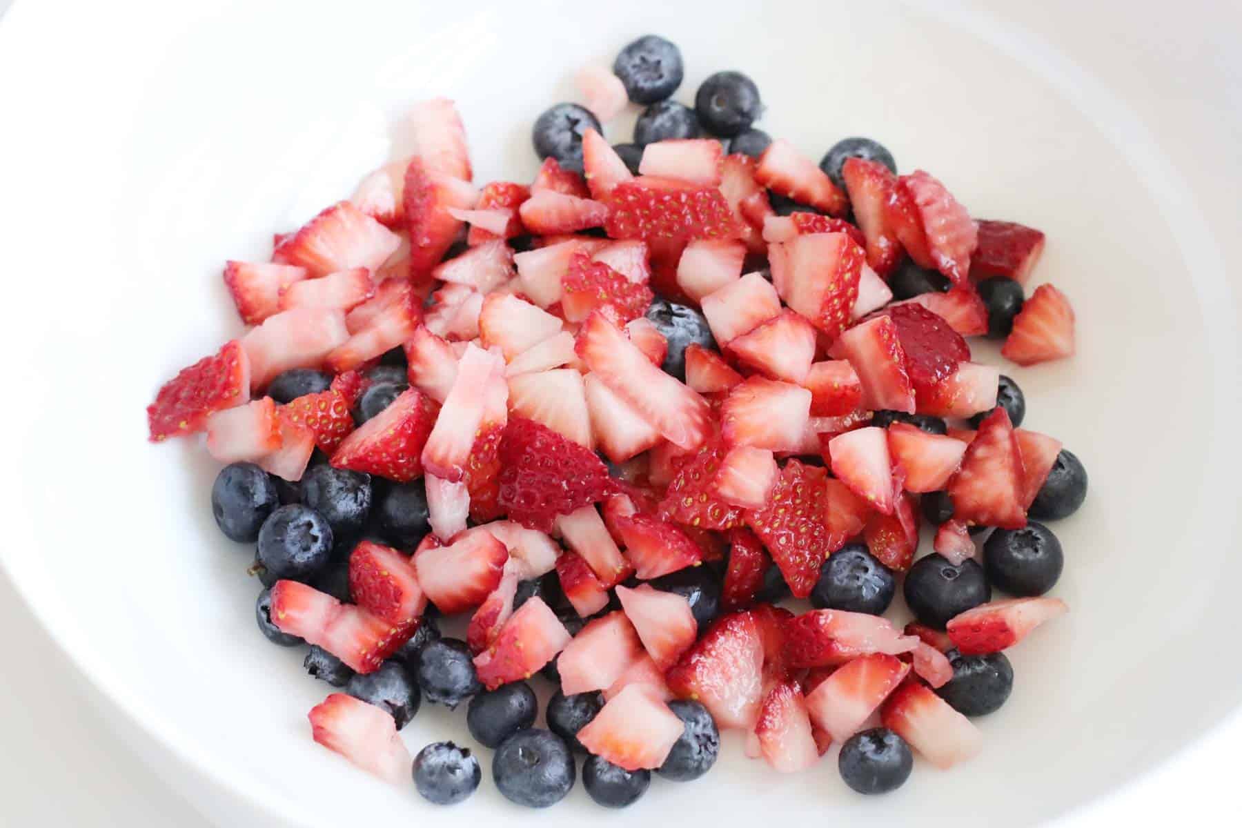 chopped strawberries and blueberries in a large bowl