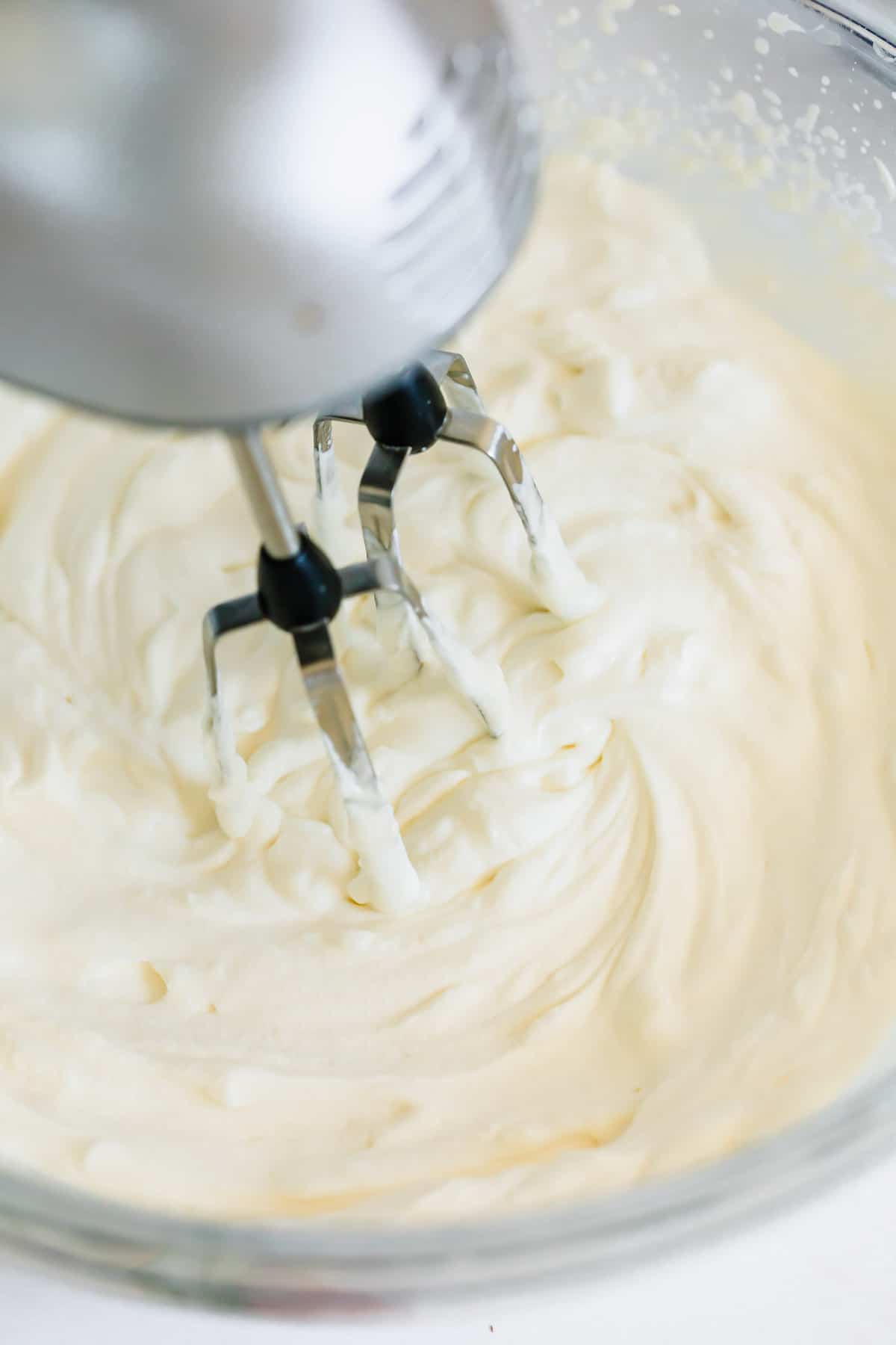 Homemade Whipped Cream Being Beaten in a Glass Mixing Bowl