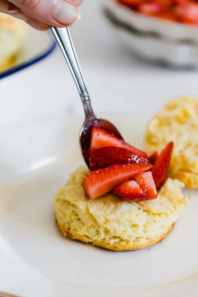 Strawberry Filling Being Spooned Onto Half of a Gluten-Free Sweet Biscuit