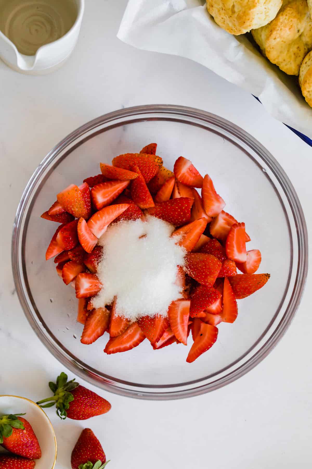 Quartered Strawberries in a Glass Bowl with Two Tablespoons of Sugar