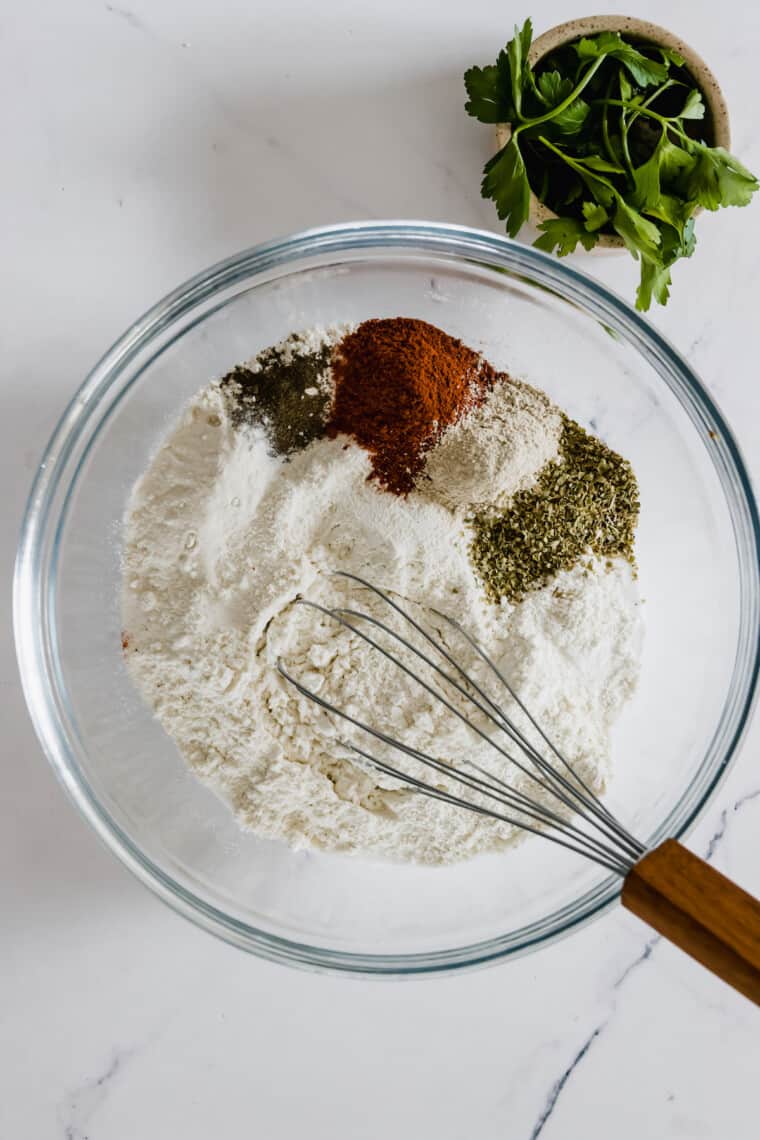 Flour, Salt, Pepper, Paprika, Garlic Powder and Onion Powder in a Glass Mixing Bowl
