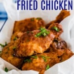 pieces of air fryer fried chicken piled in a serving dish and garnished with parsley