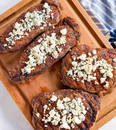 The Top View of Four Blackened Steaks Topped with Crumbled Blue Cheese