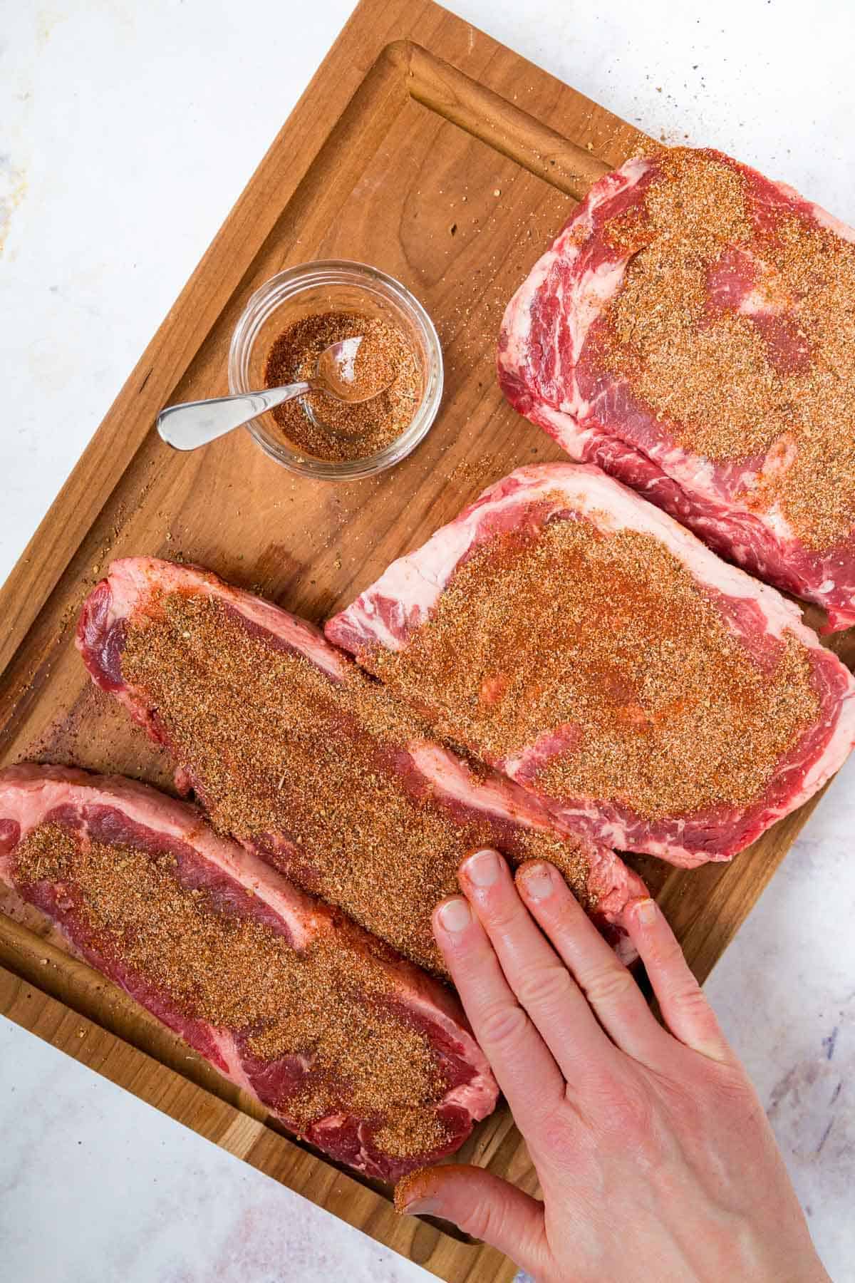 The Spice Mixture Being Rubbed Onto the Second Side of the Steaks