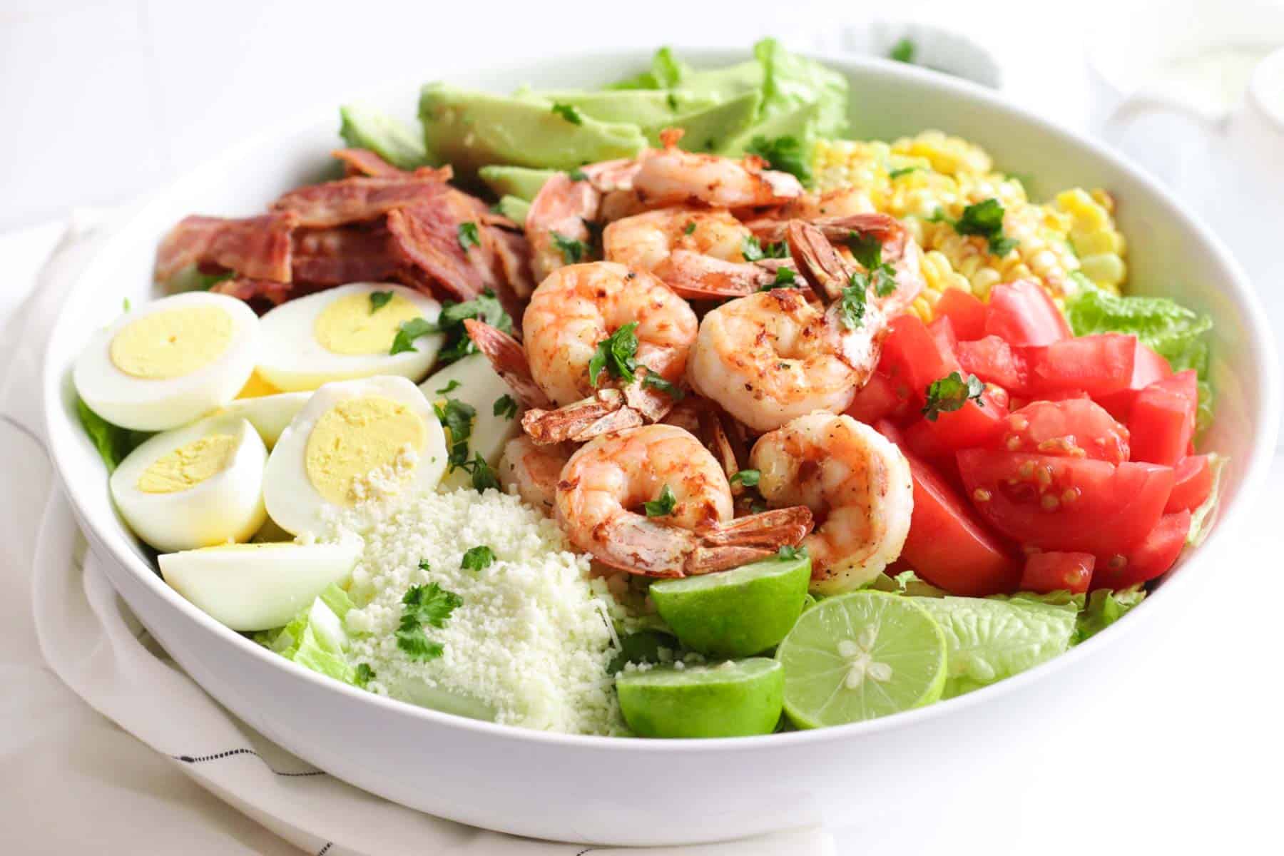 final salad now topped with the grilled shrimp in a large white bowl