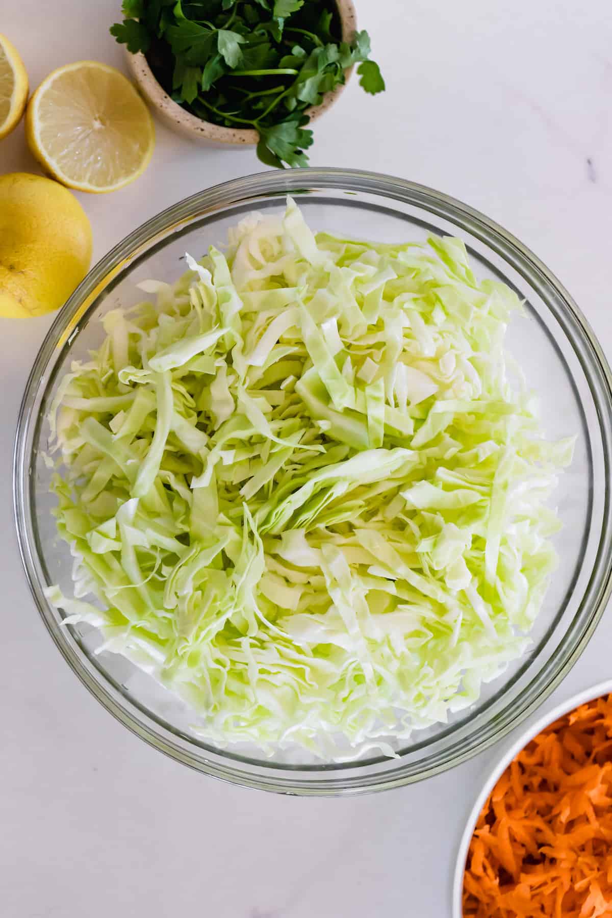 Chopped Cabbage in a Glass Mixing Bowl on a Countertop