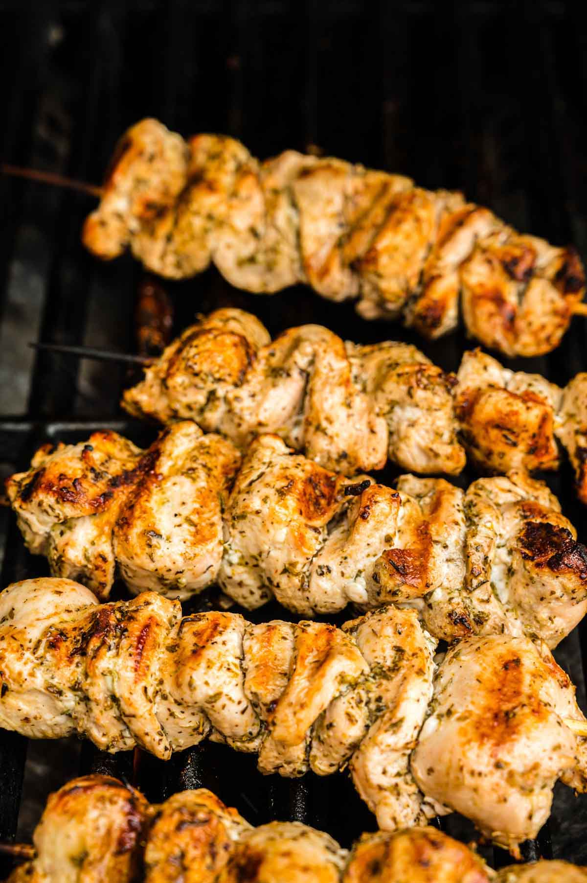 A Close-Up Image of Golden-Brown Chicken Souvlaki on Top of a Grill