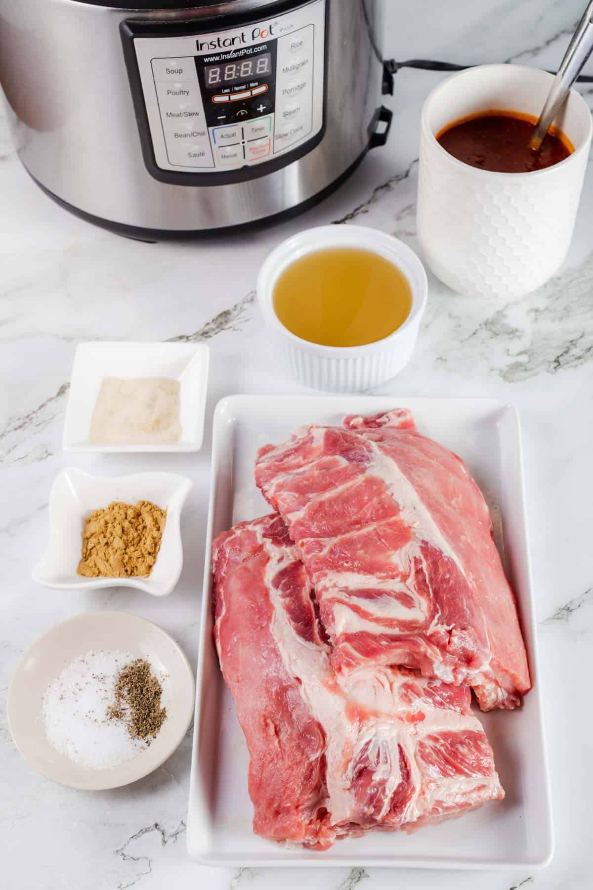 Baby Back Ribs, Ground Ginger, Tomato Paste and the Rest of the Rib Ingredients on a Marble Countertop with an Instant Pot