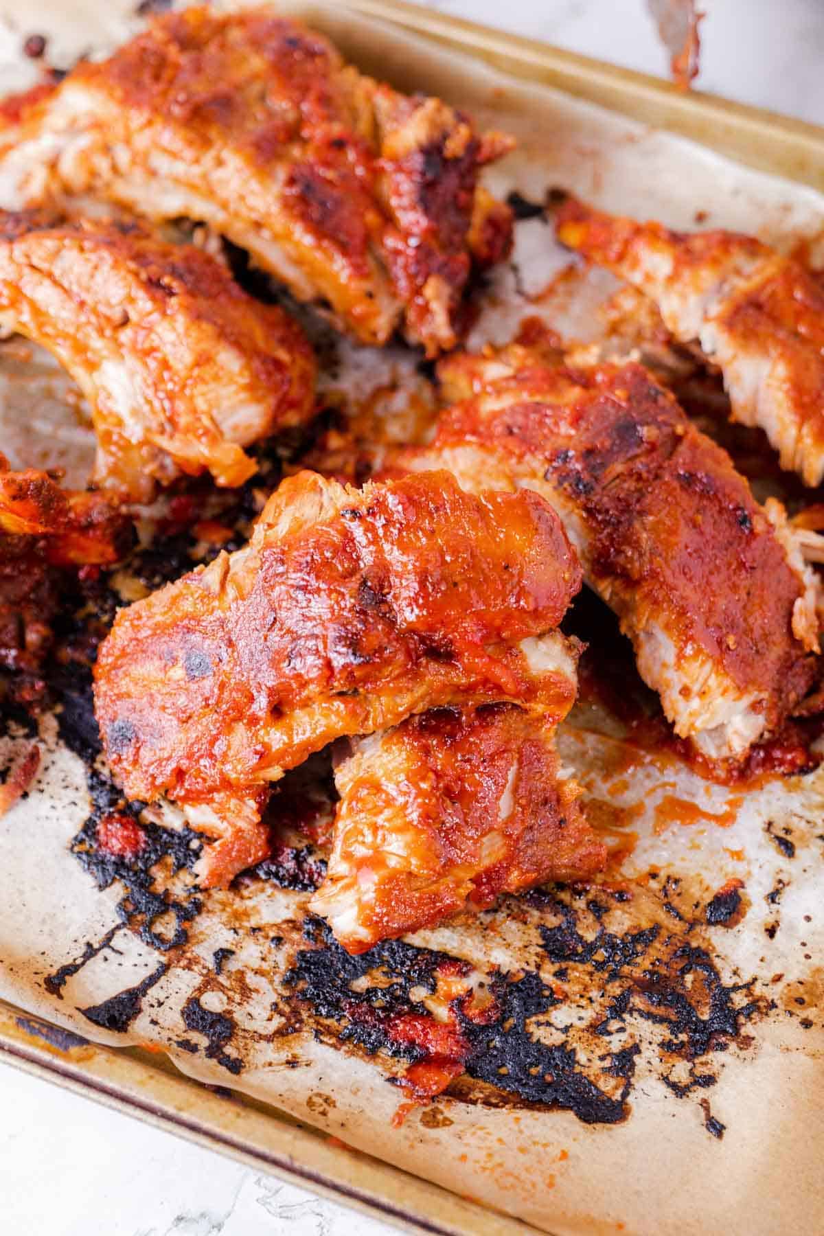A Close-Up Shot of Instant Pot Honey BBQ Ribs on a Parchment-Lined Pan