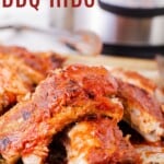cut up barbecue ribs on a baking sheet in front of an Instant Pot
