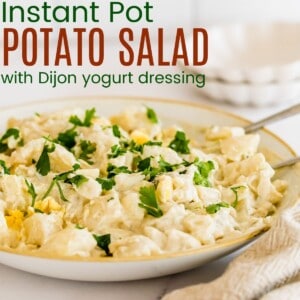 serving bowl of potato salad with two spoons in it