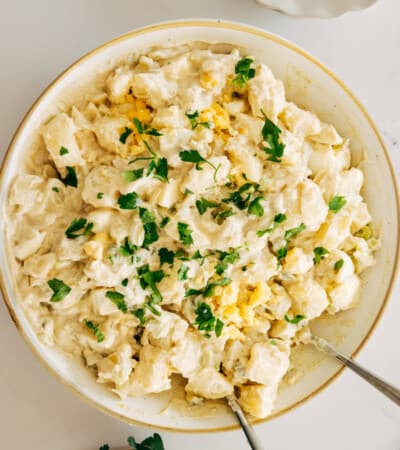 The Bird's-Eye View of a Plate of Potato Salad with Two Forks Digging in