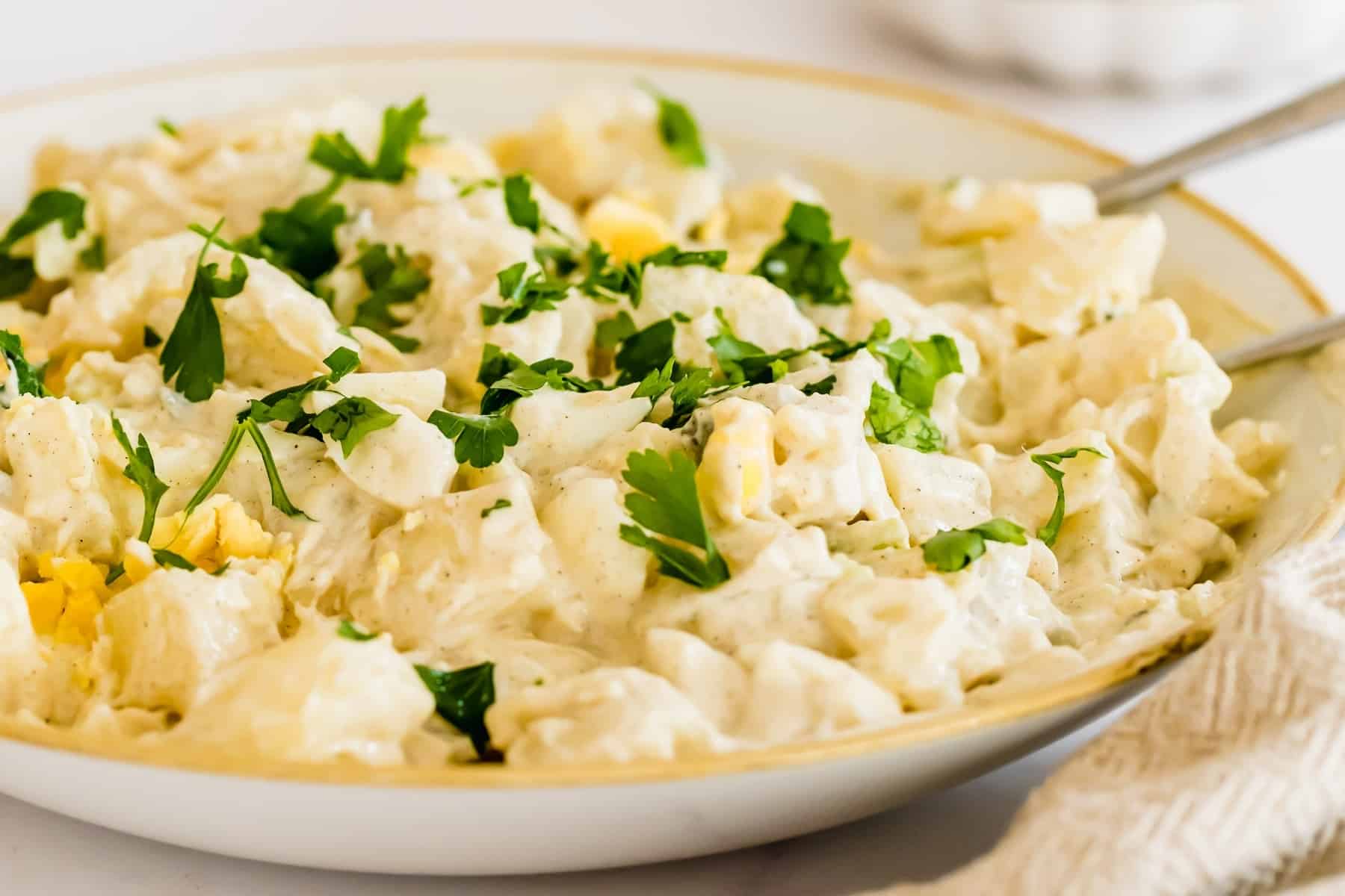 Instant Pot potato salad in a serving bowl garnished with parsley