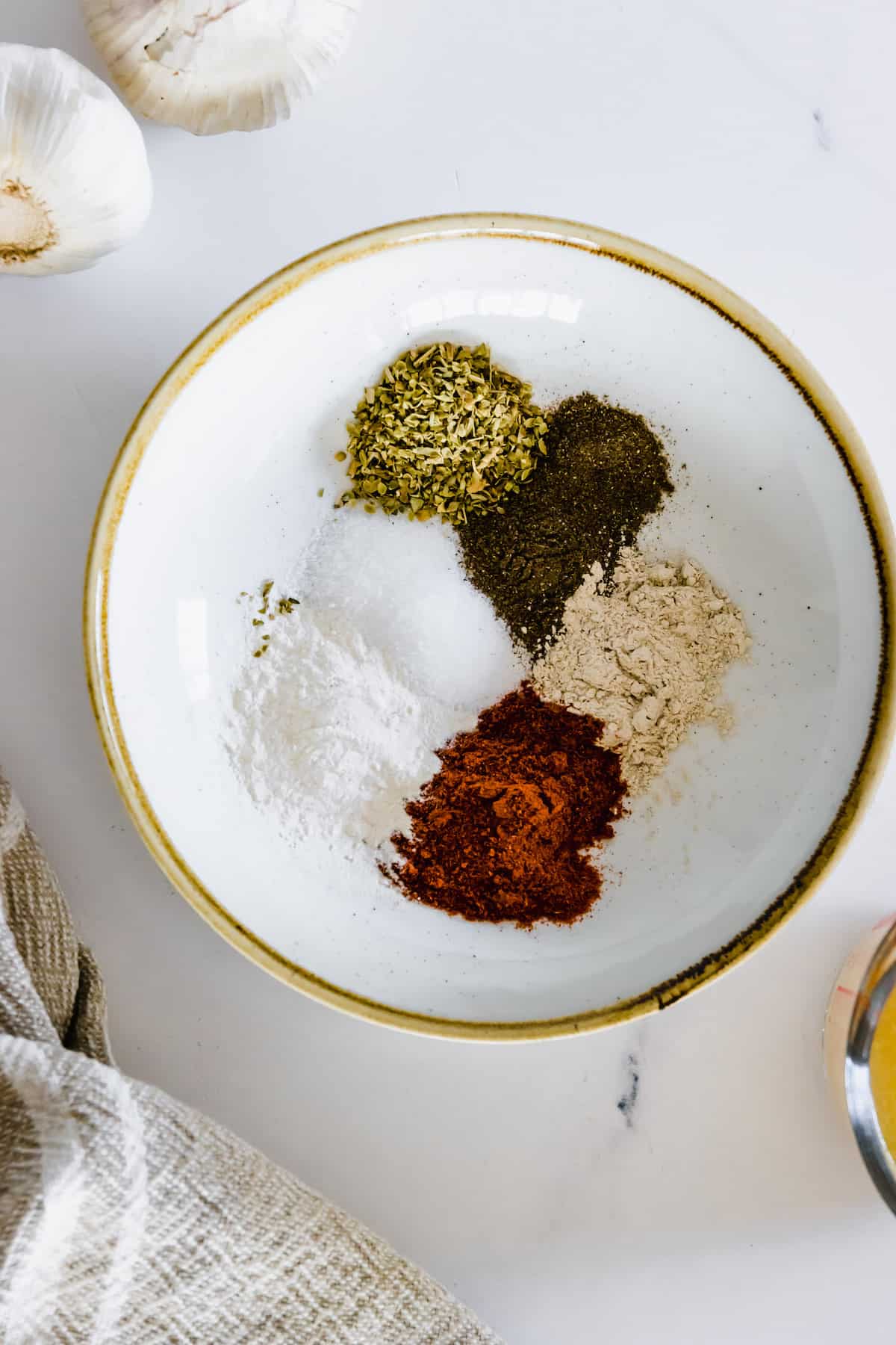 Salt, Oregano, Smoked Paprika and the Rest of the Spice Rub Ingredients in a White Bowl