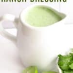 A small white jug of a green-colored salad dressing with halves of limes and a dish of cilantro next to it with text overlay that says "Jalapeno Ranch Dressing".