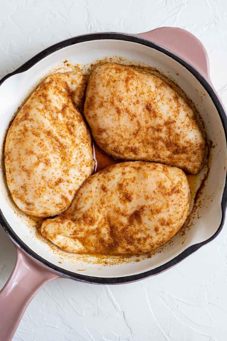 baked chicken breasts with spices in a skillet