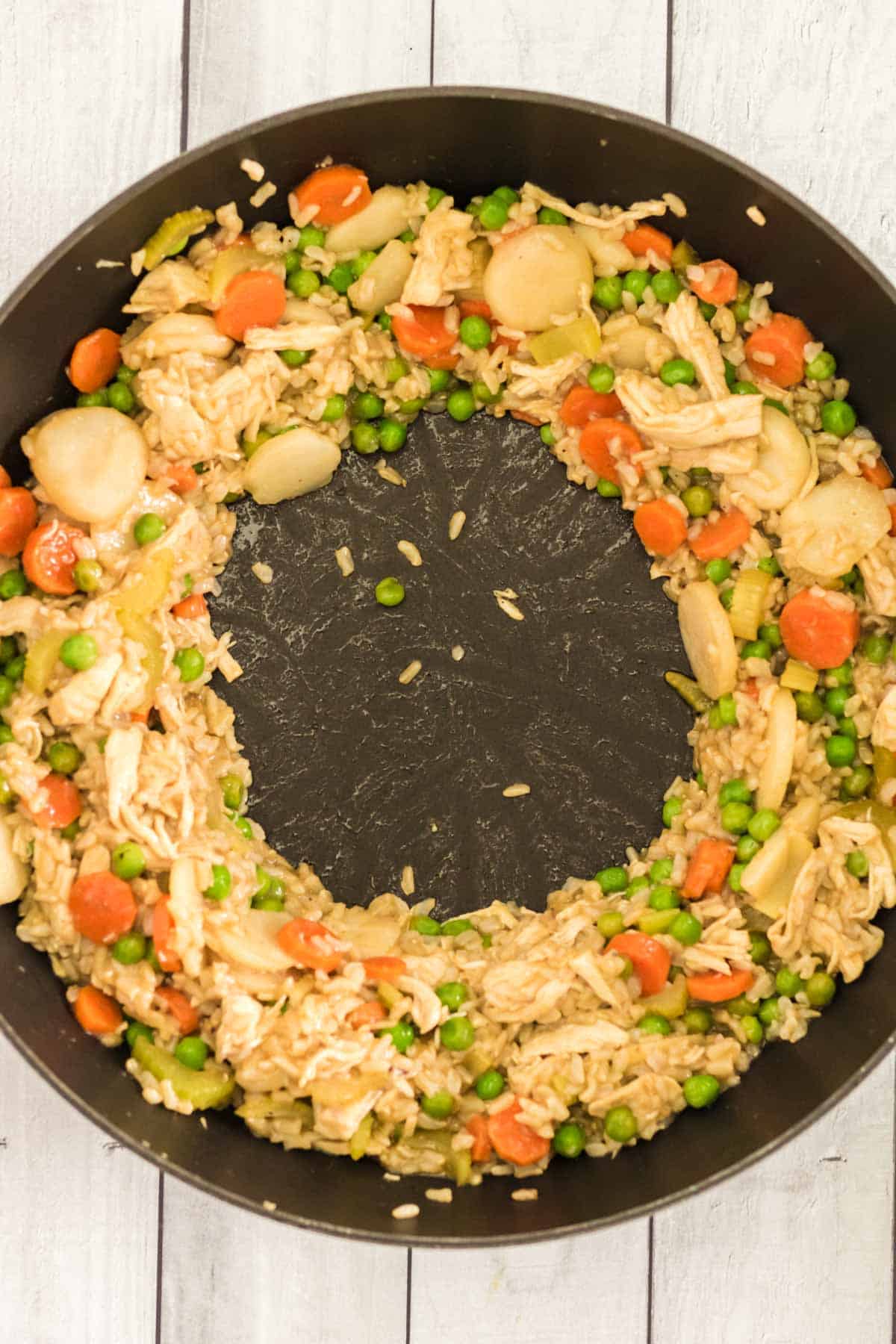 chicken fried rice in a skillet with an empty center for eggs