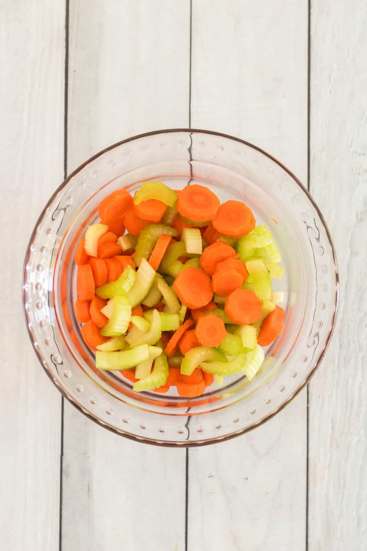 glass bowl with sliced carrots and celery