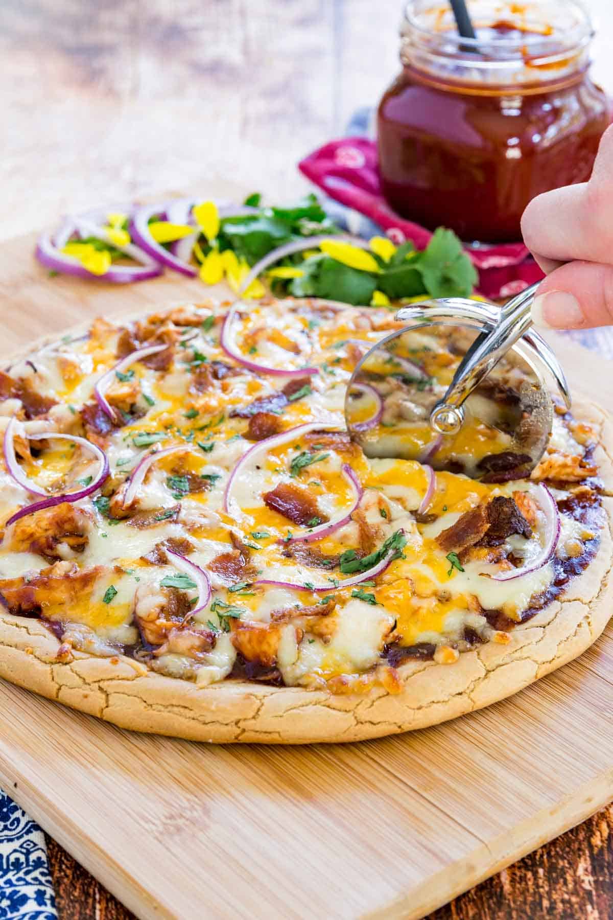 cutting into the finished pizza with a pizza slicer