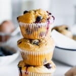 three gluten free blueberry muffins stacked on top of each other