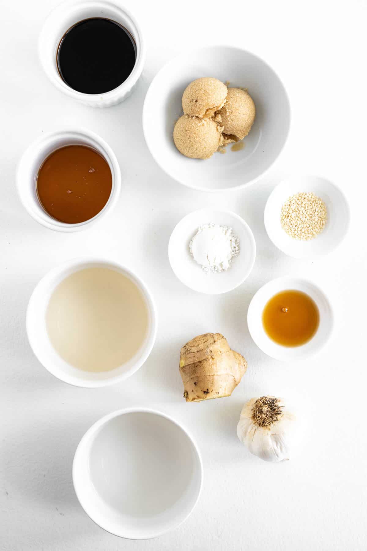 ingredients for gluten-free teriyaki sauce in small bowls, including soy sauce, brown sugar, honey and ginger