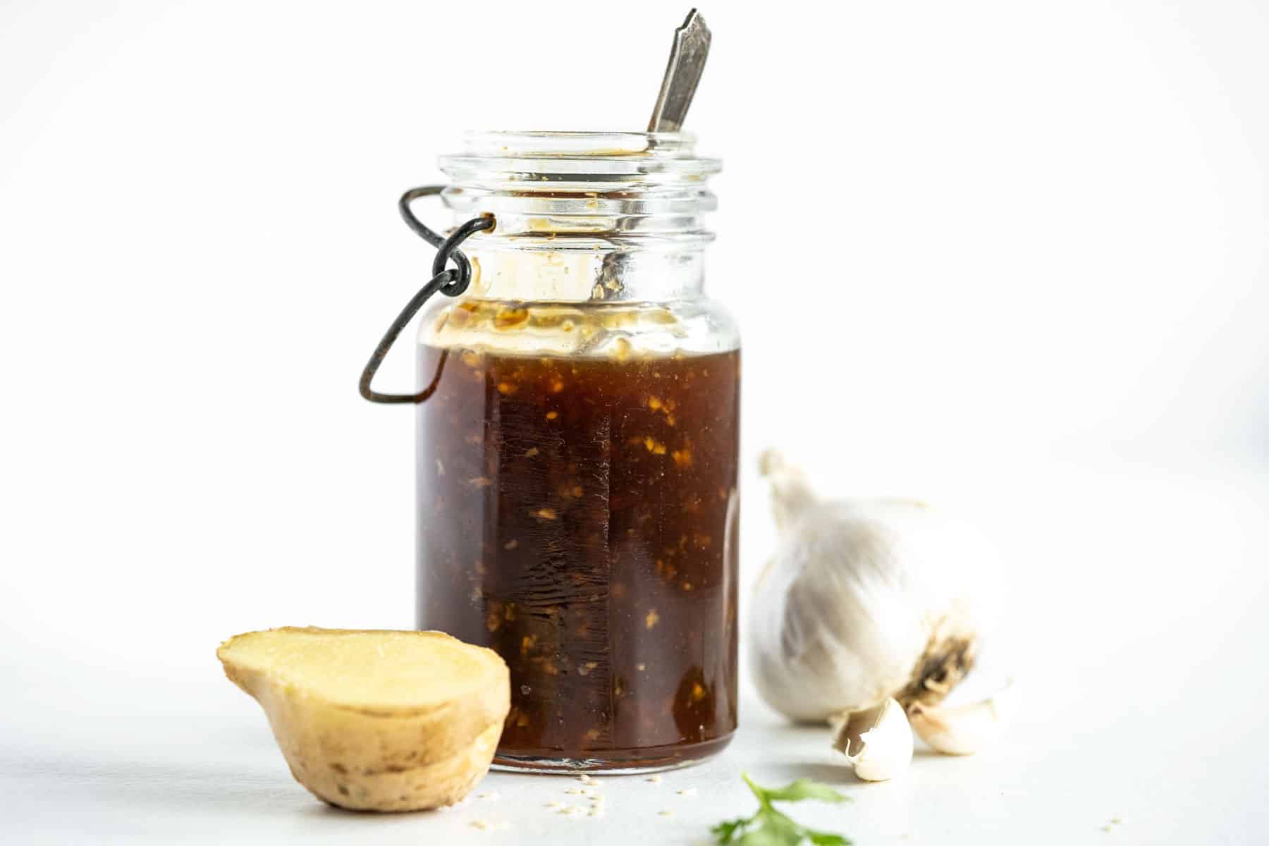 glass jar of gluten-free teriyaki sauce with fresh ginger and garlic