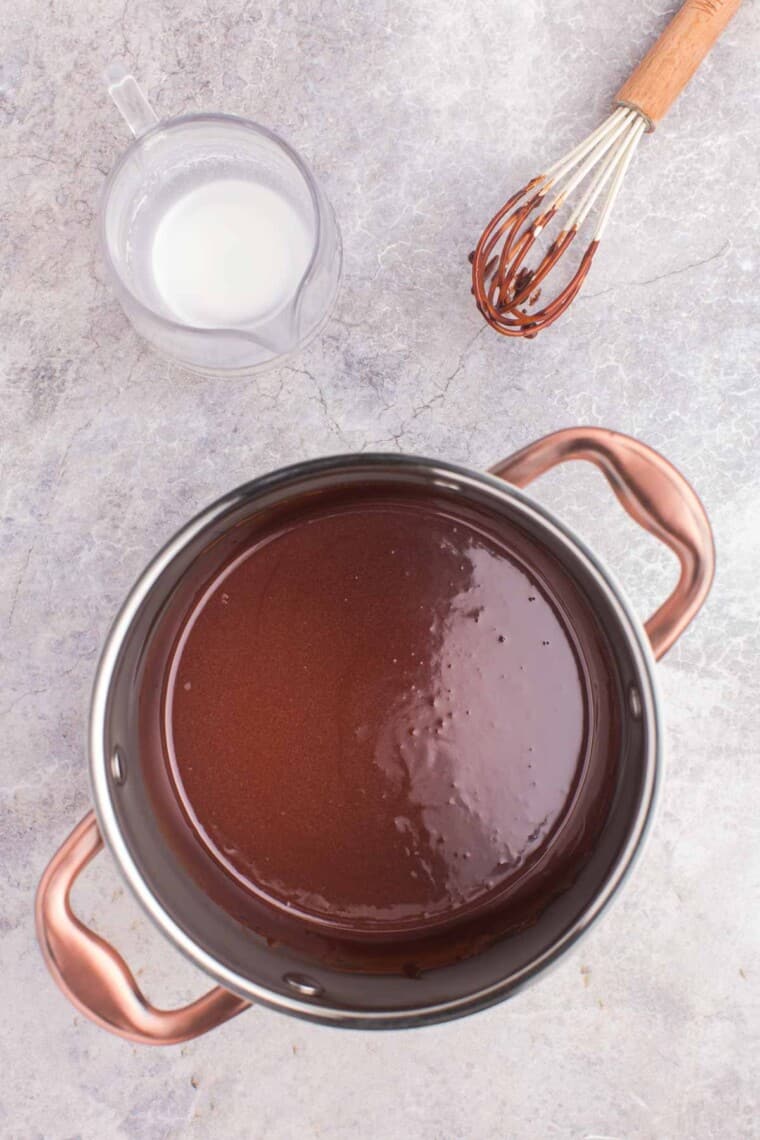 hot fudge sauce in a pot with a whisk next to it